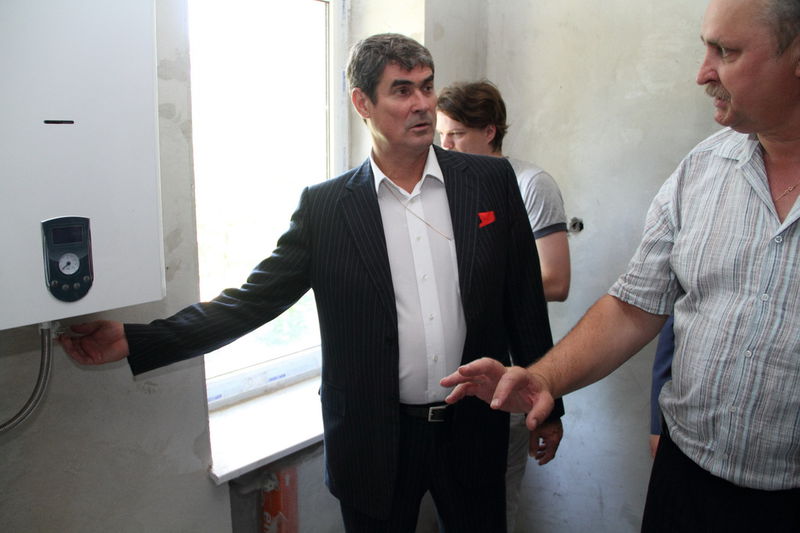 Господар демонструє газовий котел та індивідуальне опалення